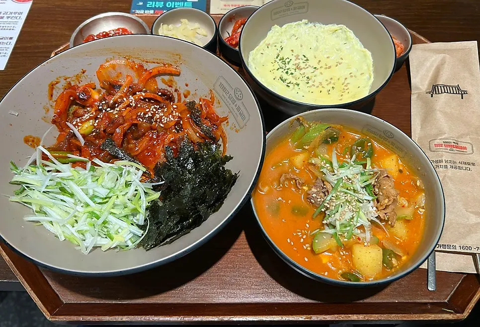 Korean meal spread with rice bowl, jjageuli, steamed egg, and side dishes