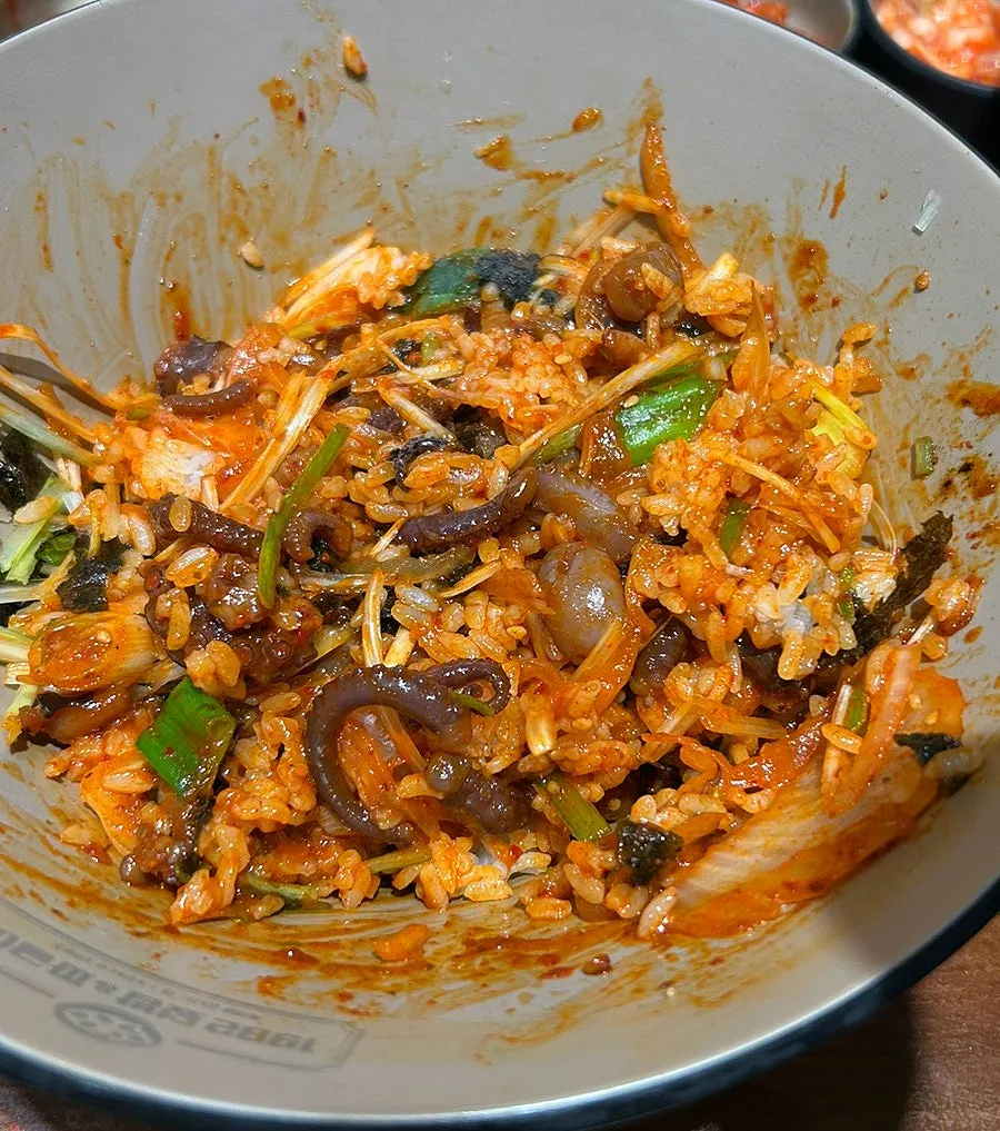 Close-up of the spicy octopus rice bowl drizzled with sesame oil