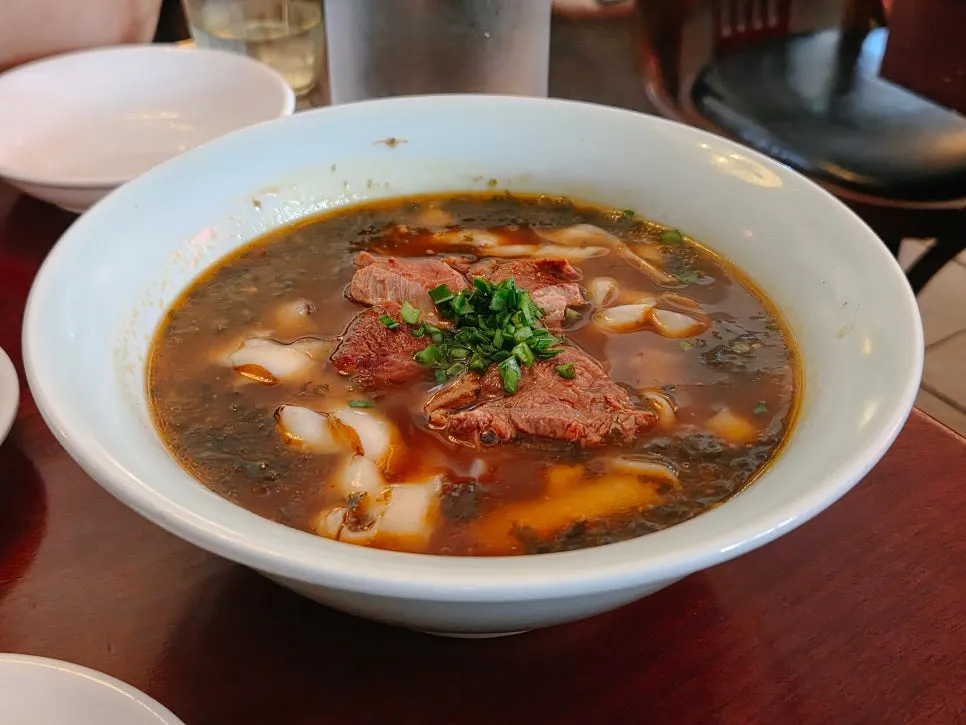 Beef hand-cut noodles and guobaorou set on the table