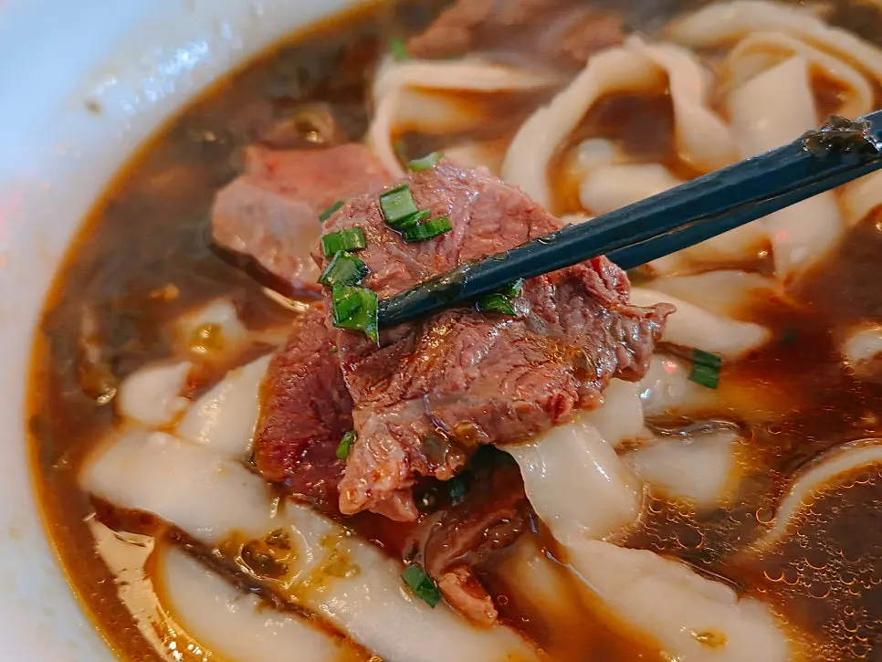 Knife-shaved noodles lifted up from the bowl