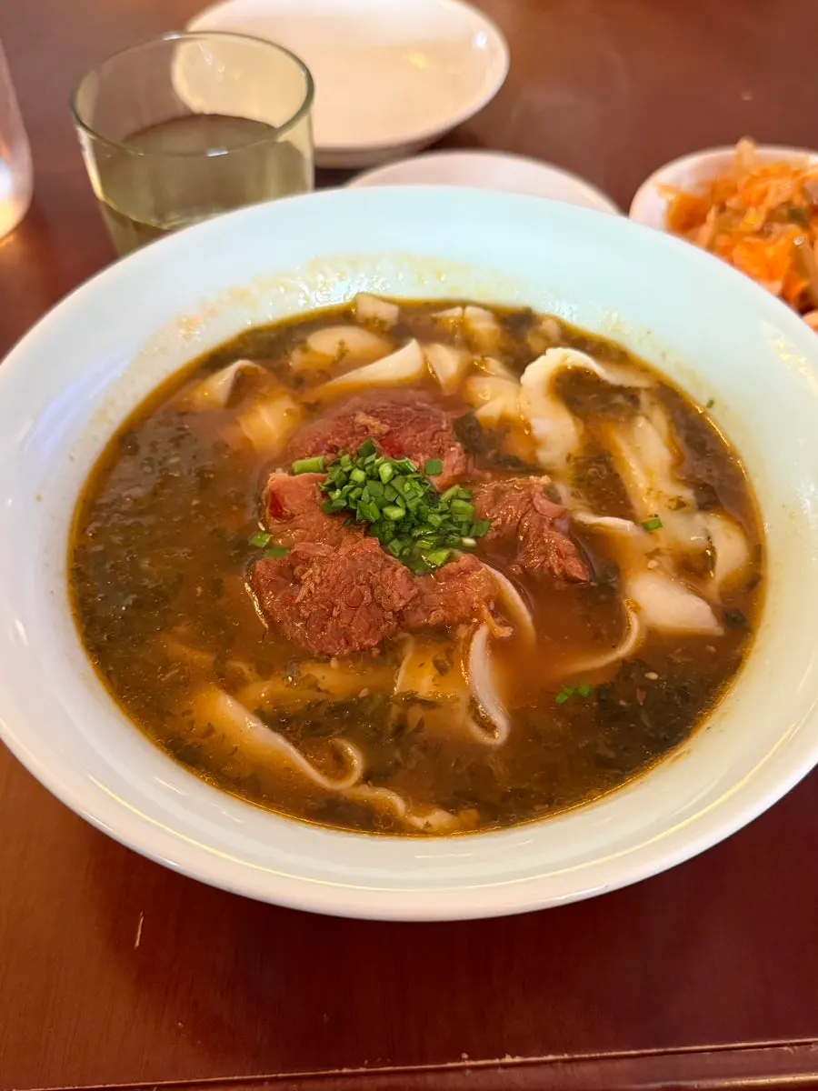 A bowl of beef dosakmyeon topped with beef
