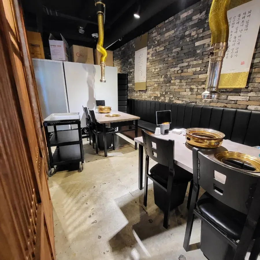 벽돌 벽면과 우드톤 테이블의 매장 내부 전경