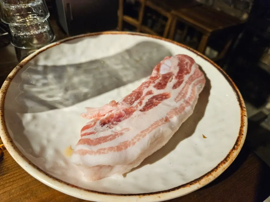 Raw pork belly placed on the grill