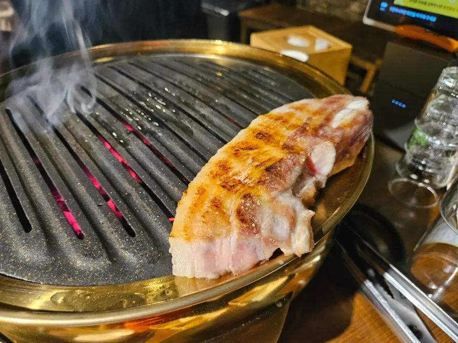 Cross-section of pork belly cooking on the grill