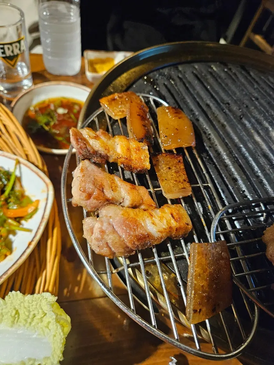 Grilled pork belly alongside a shot of soju