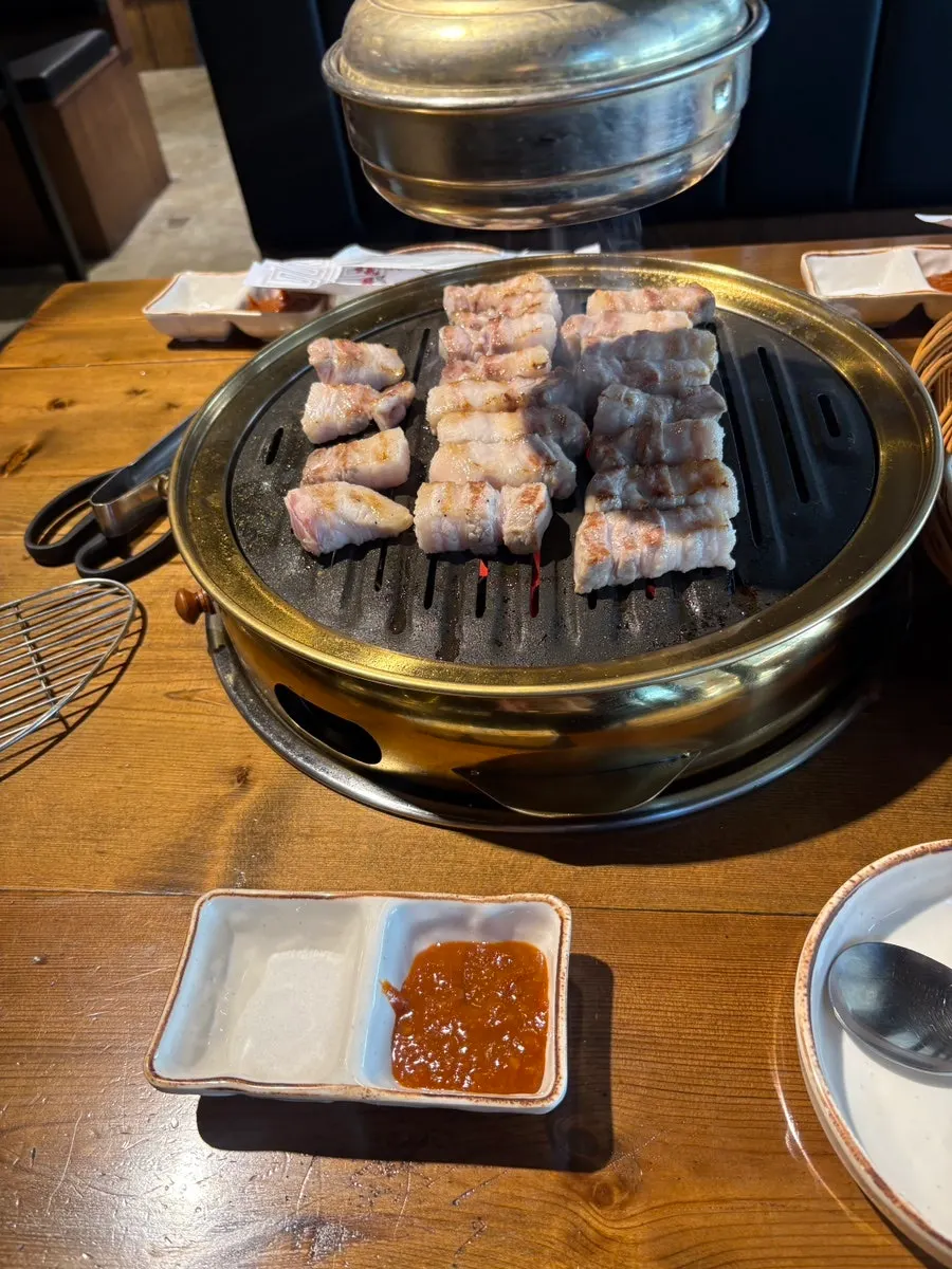 Staff member grilling pork belly on the pan