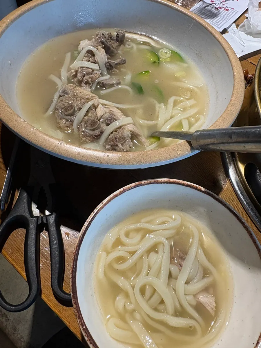 Kalguksu with pork backbone served alongside kimchi