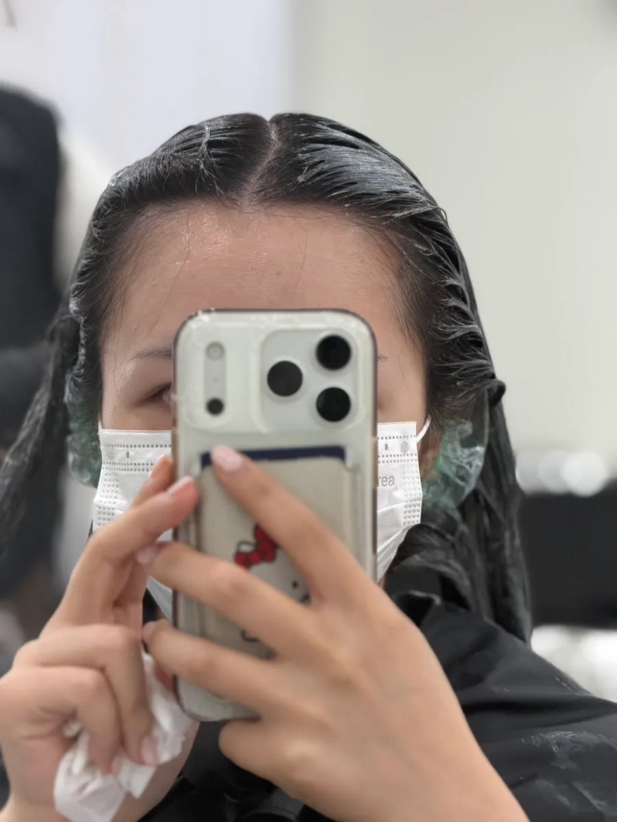 Two designers applying the dye to sections of hair