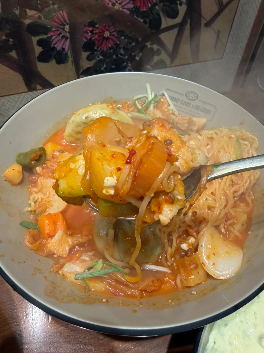 Jjageuli filled with dumplings, rice cakes and ramyeon noodles