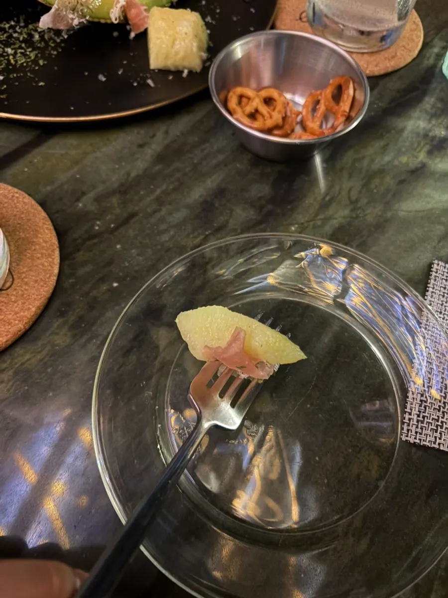 Side dish plate topped with melon and prosciutto