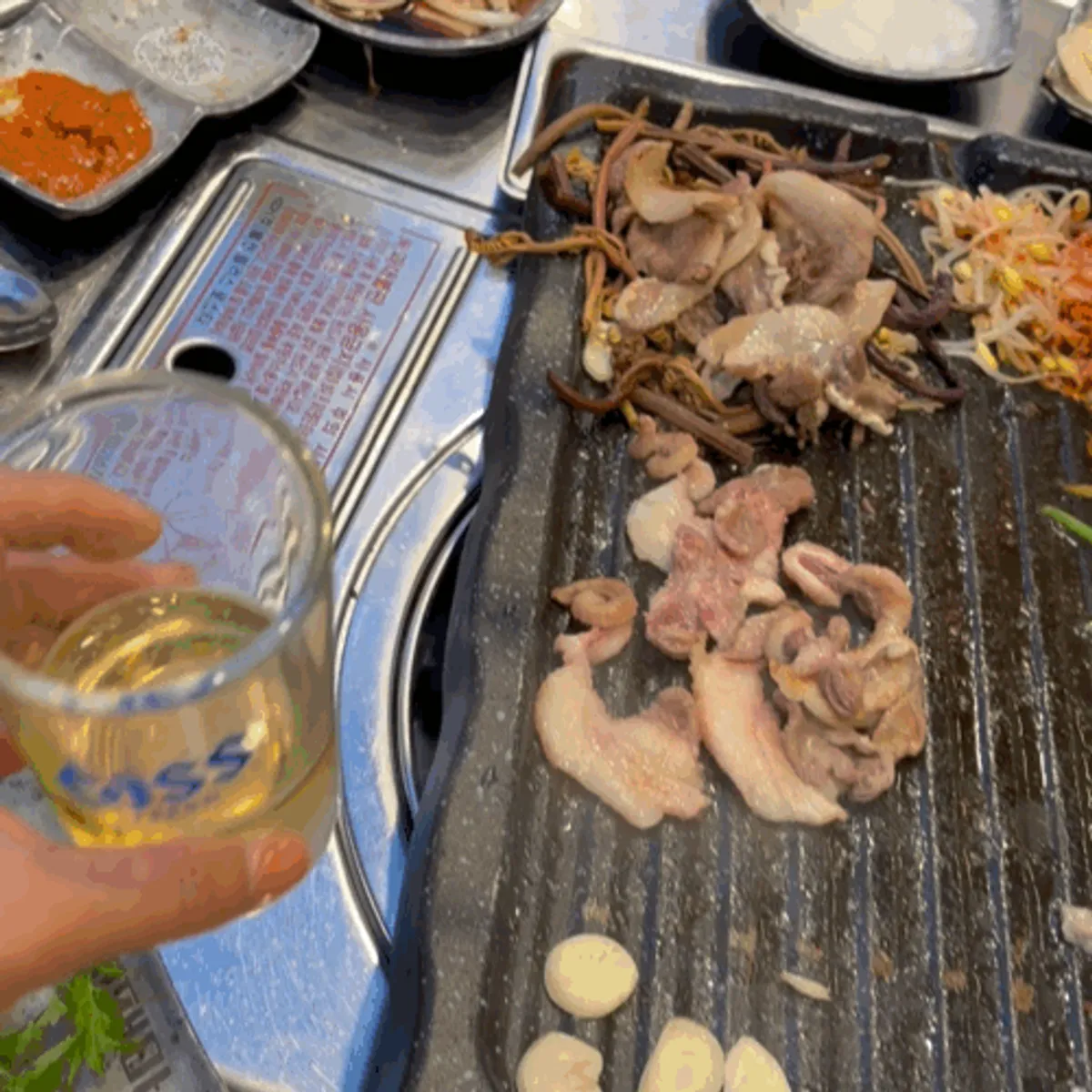 A piece of grilled brisket with a soju-beer mix glass