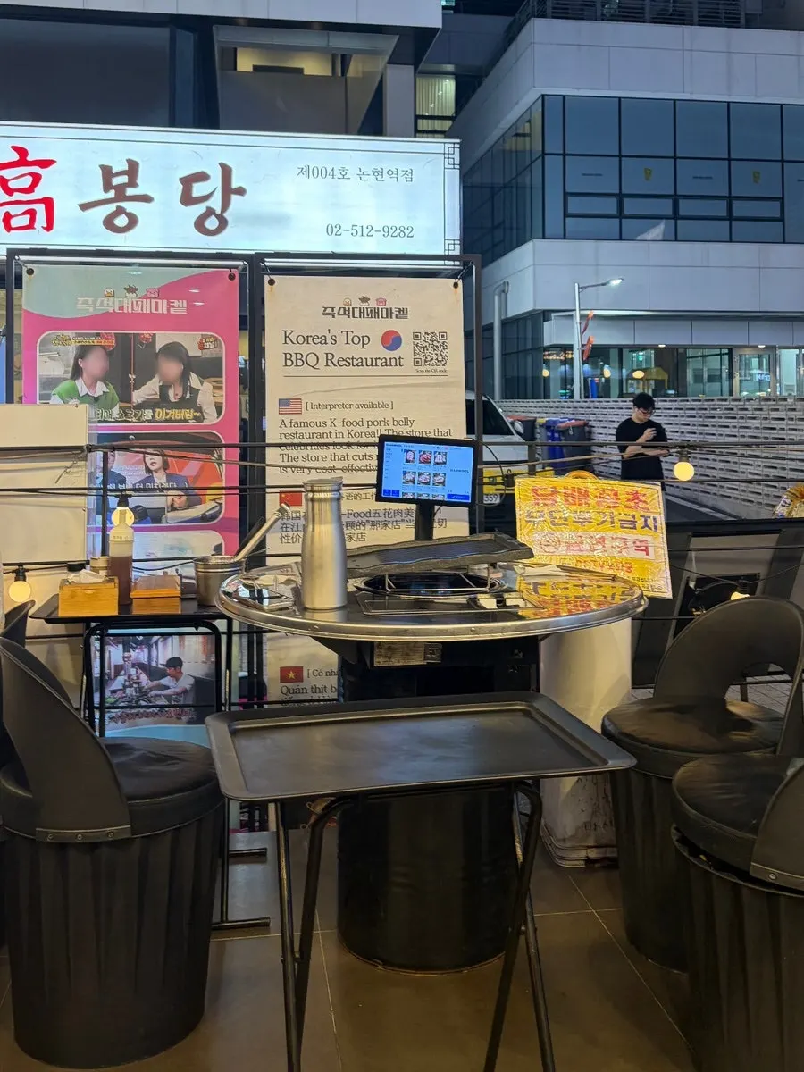 Outdoor seating at Daepae Market Gangnam Nonhyeon Branch at night