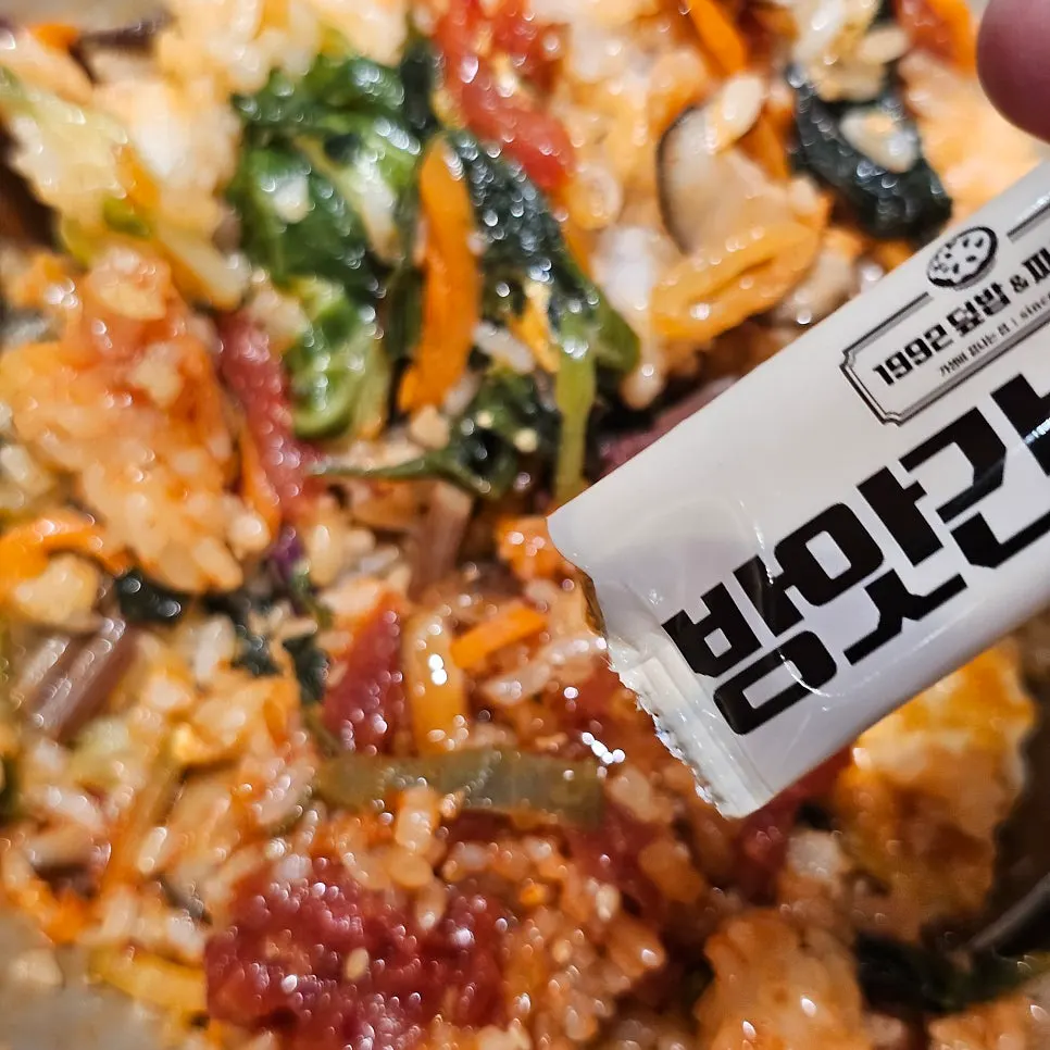 A spoonful of bibimbap mixed with sesame oil