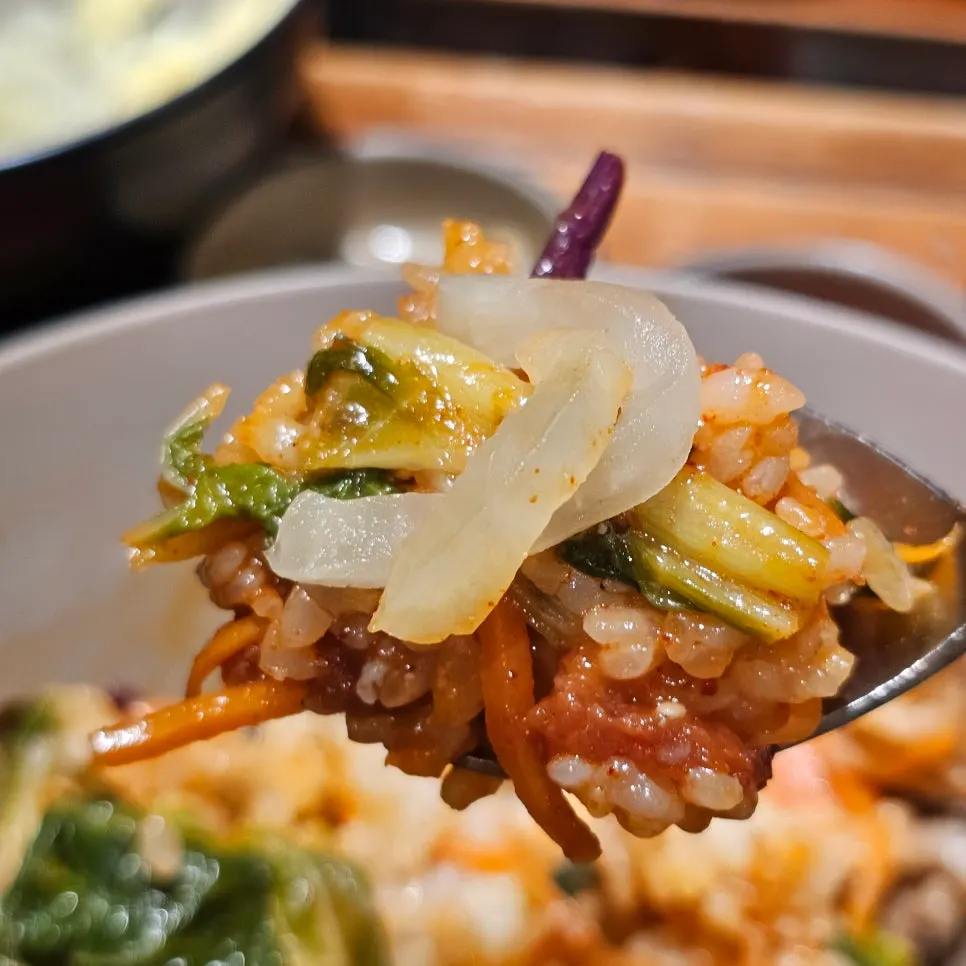 A bite of bibimbap paired with kimchi