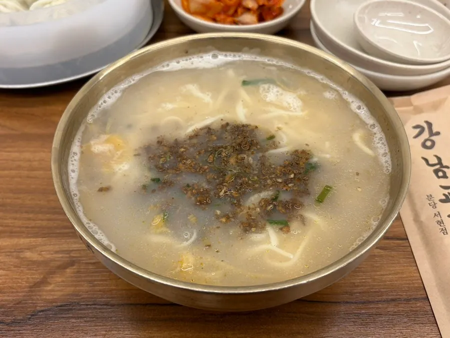 Bowl of kalguksu topped with meat and dumplings