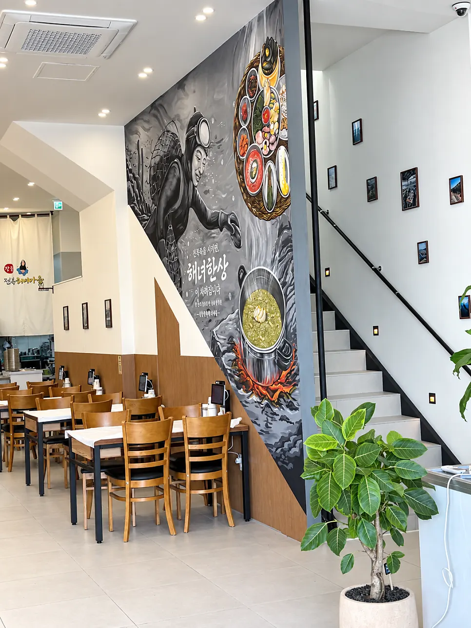 1st-floor dining area with haenyeo photos on the wall