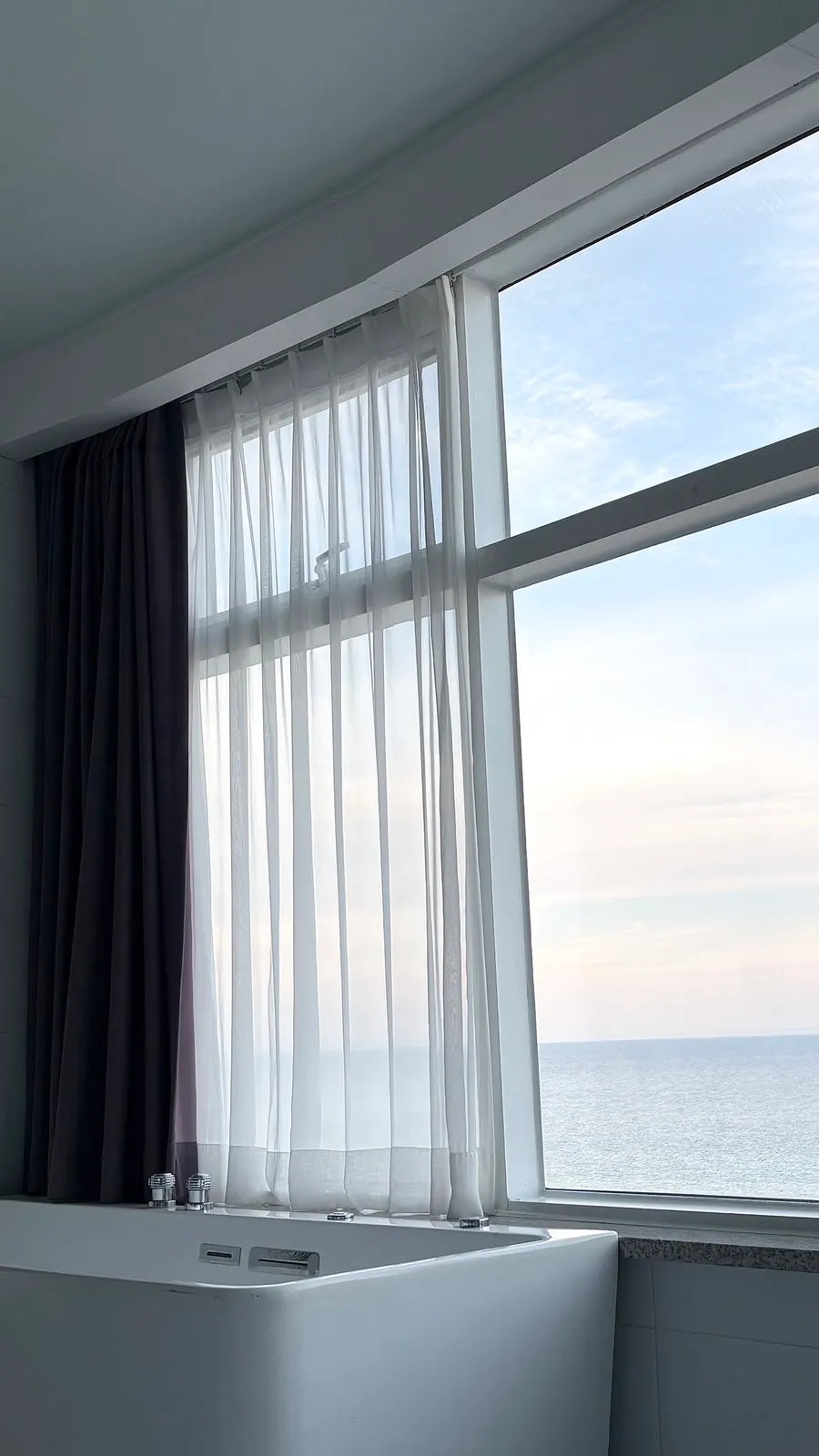Ocean view of Anmok Beach seen through the window of Room 401