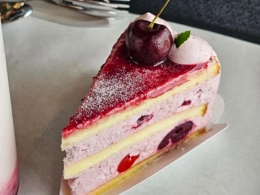 Cross-section of cherry cream cake cut with a fork