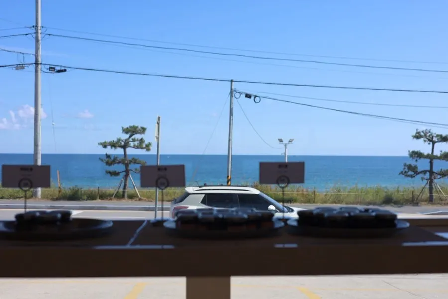 View of blue sky and sea from a window seat at Baegya Coffee