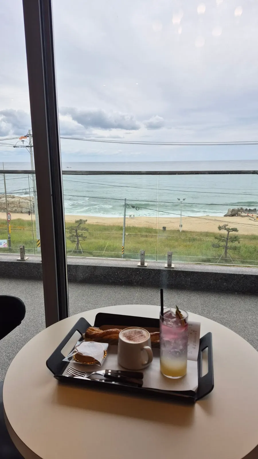 View of Sacheonjin Beach through the window at Baegya Coffee