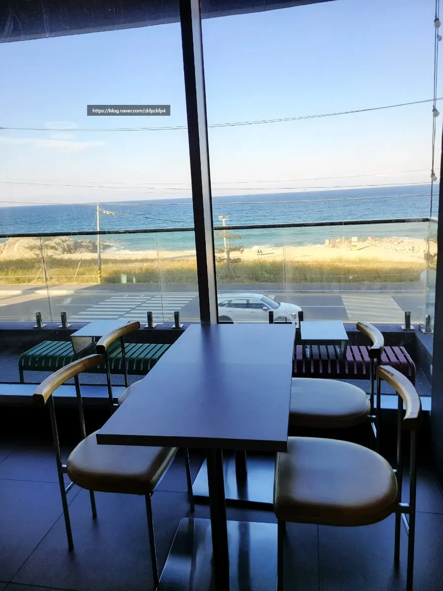 Indoor seating at Baegya Coffee with sea view through the window