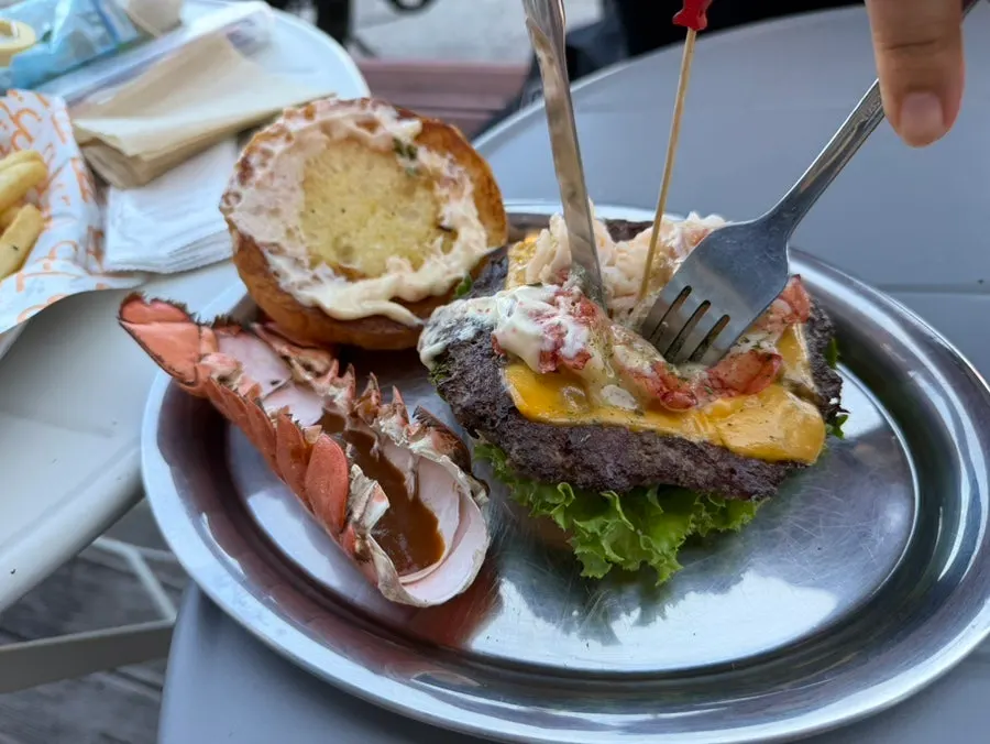 Lobster burger, fries, and corn ribs served together