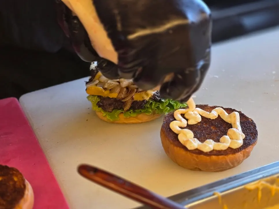 Beef patty and onions grilling on the griddle