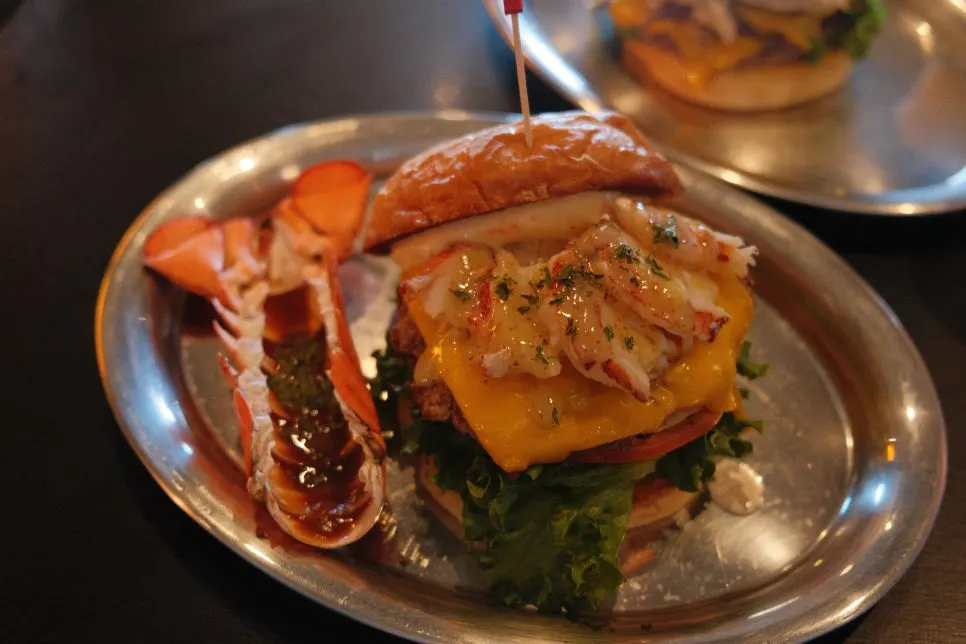 Table setup with lobster burger, Daegwallyeong songgo mushroom burger, and fries