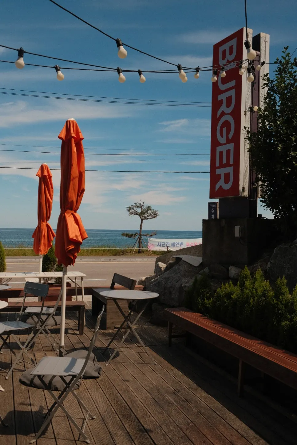 Outdoor terrace seating at Burger Bar with an ocean view