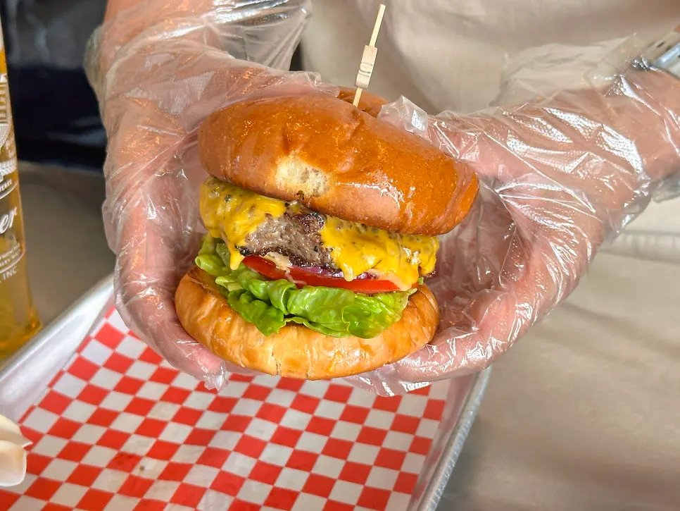 Moana Burger with tomato, lettuce, onion, and cheese