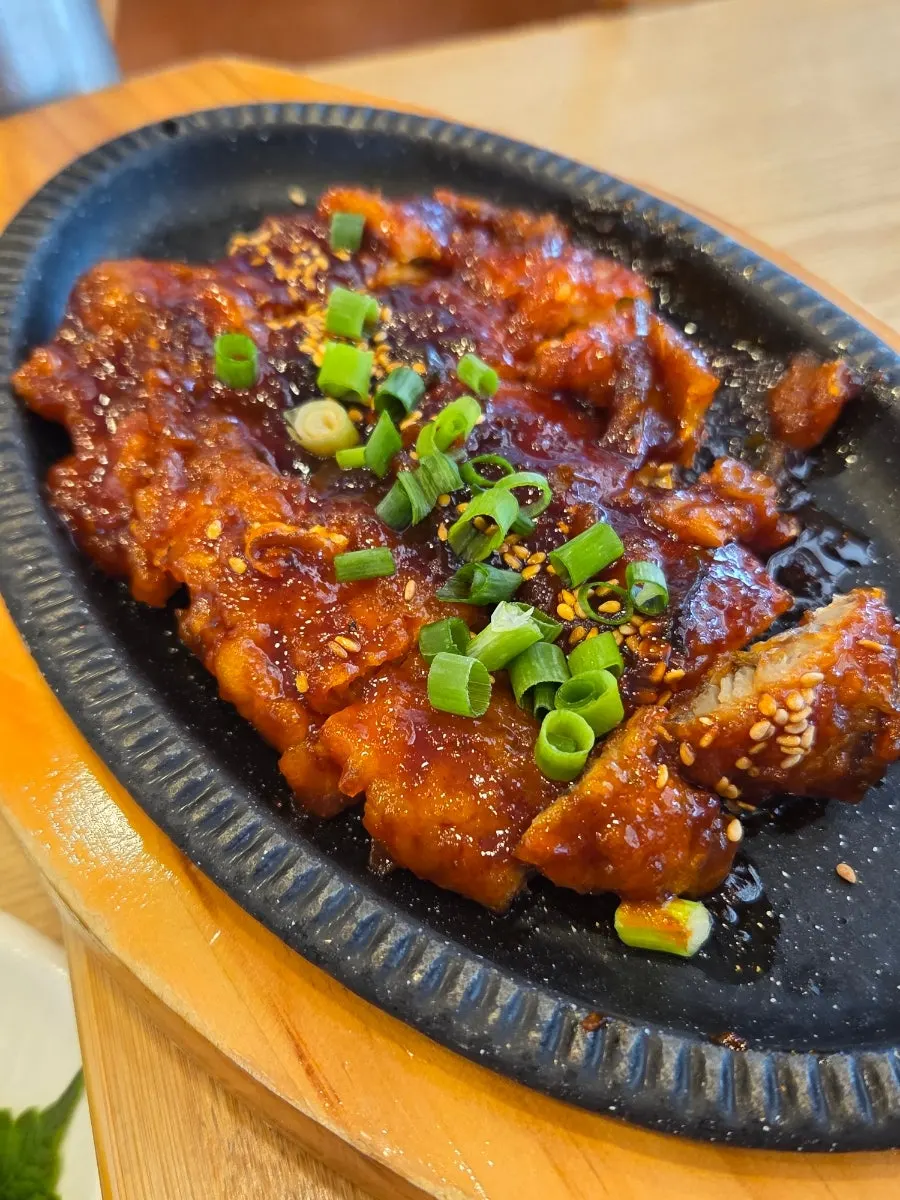 A bite of tofu topped with boiled pork