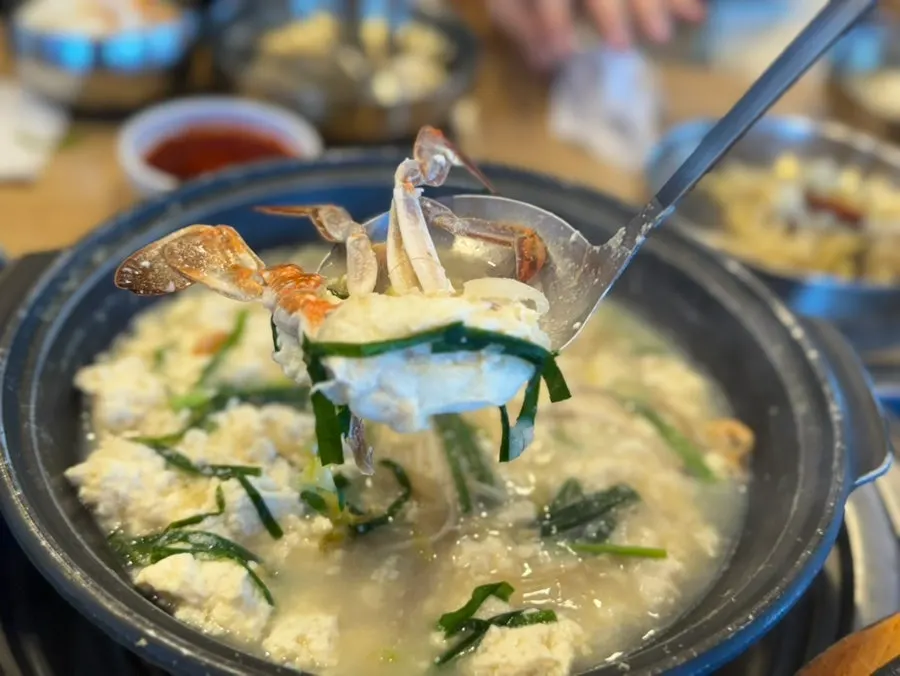 A bowl of sundubu jjigae with seasoning sauce added