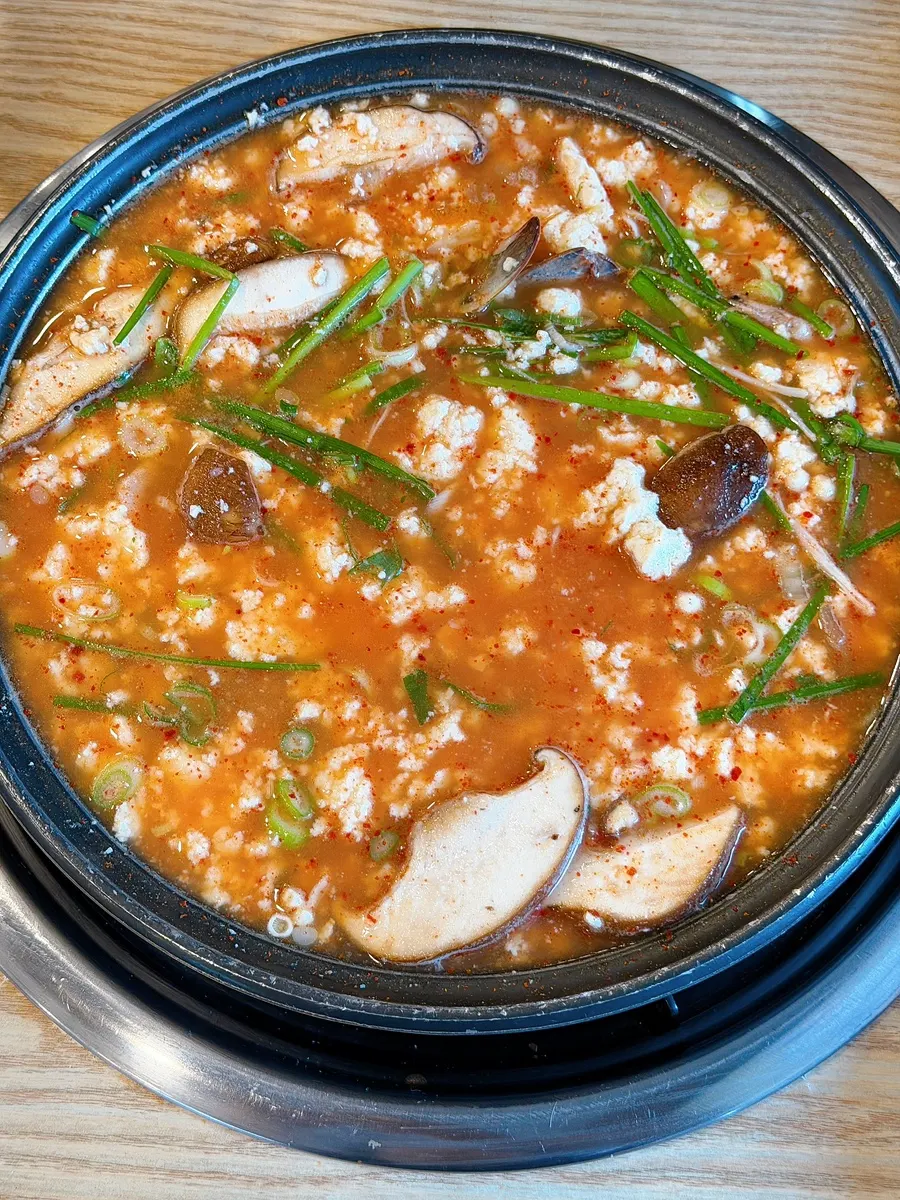 순두부 전골에 양념장을 푸는 모습