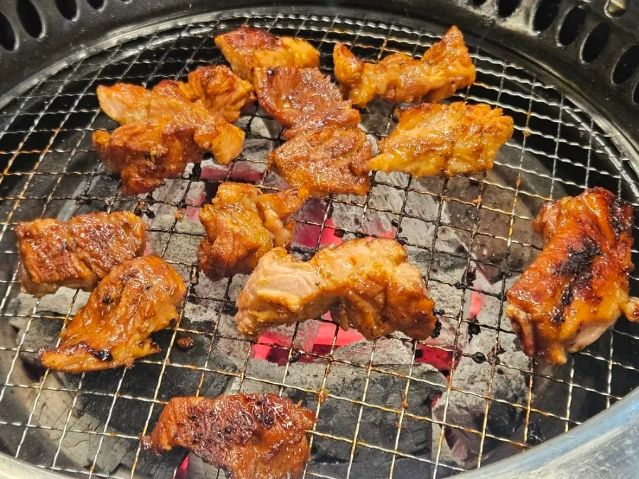 Seasoned pork galbi placed on the charcoal grill