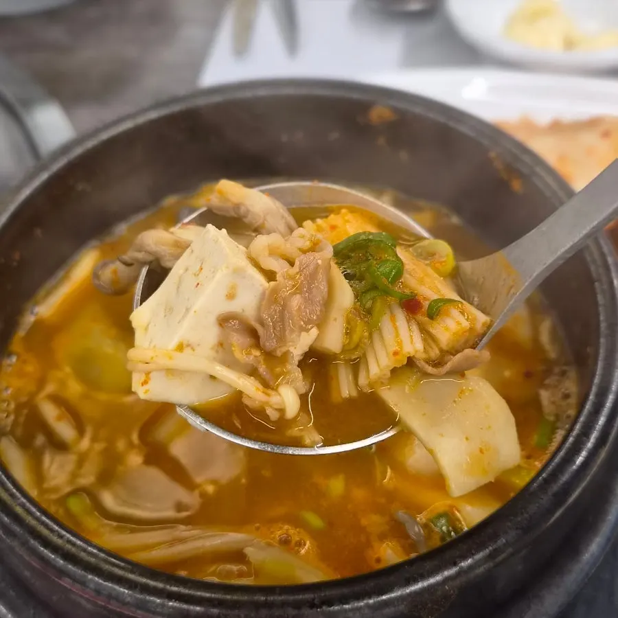Close-up of the doenjang jjigae broth with vegetables and meat