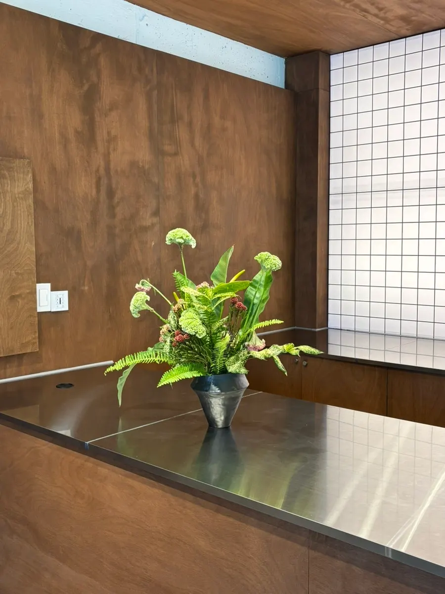 ウッドトーンのテーブルと植物のある店内