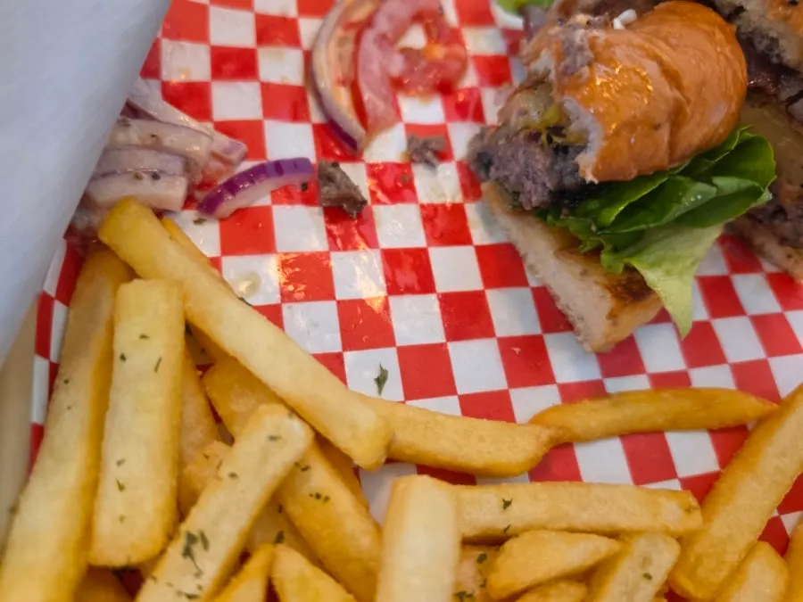 A handmade burger being cut with a knife