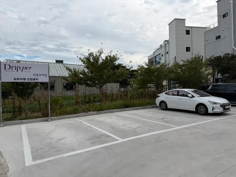 Coffee Dripper's store parking lot fitting about 13 cars