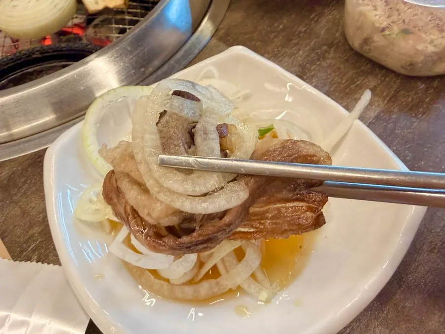 A piece of hanwoo beef eaten with pickled onions