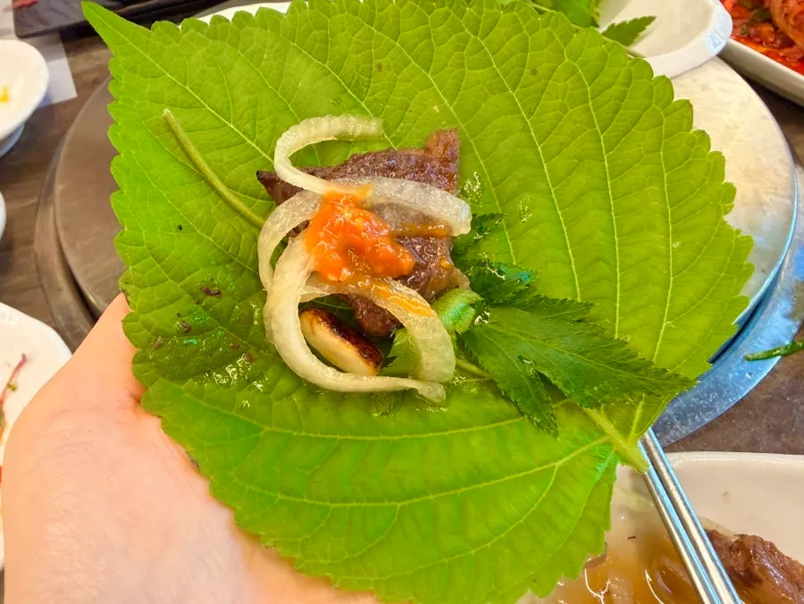 Grilled hanwoo beef placed on a lettuce wrap