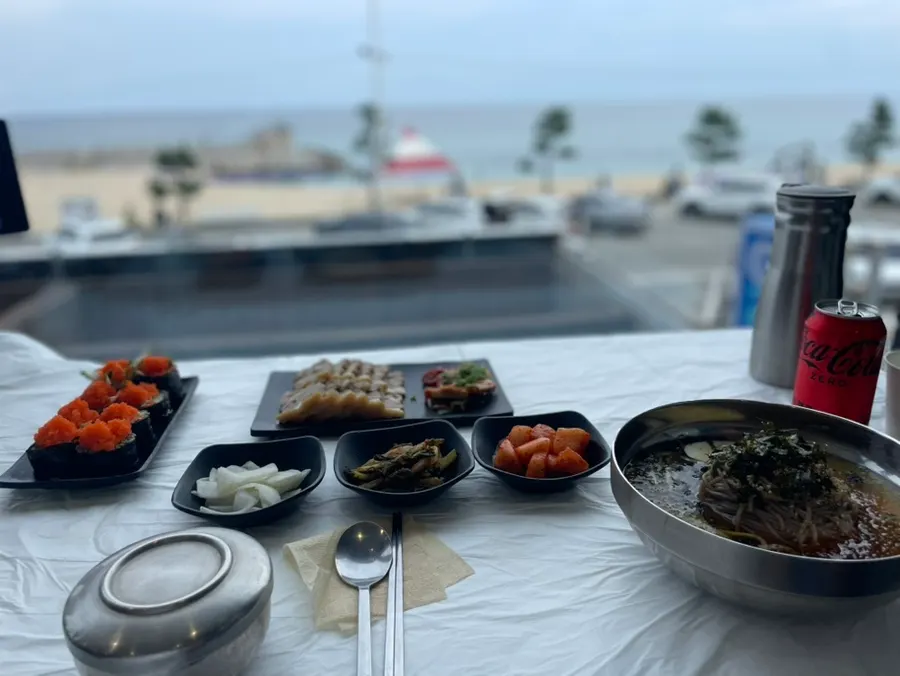 창가석에 차려진 2인세트와 날치알 메밀김밥 한 상