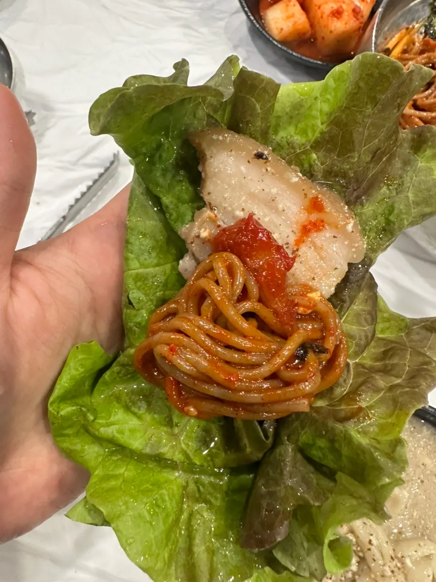 Bibim makguksu topped with pollock sikhae