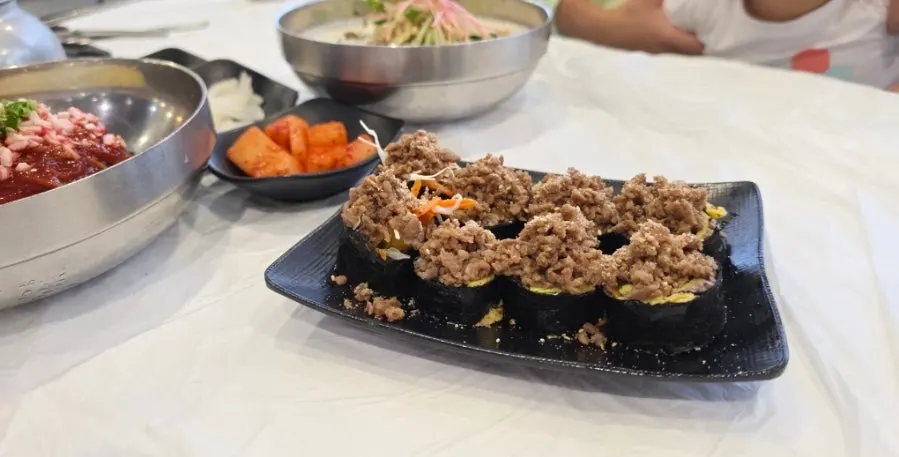 A roll of soy pork buckwheat gimbap made with buckwheat noodles
