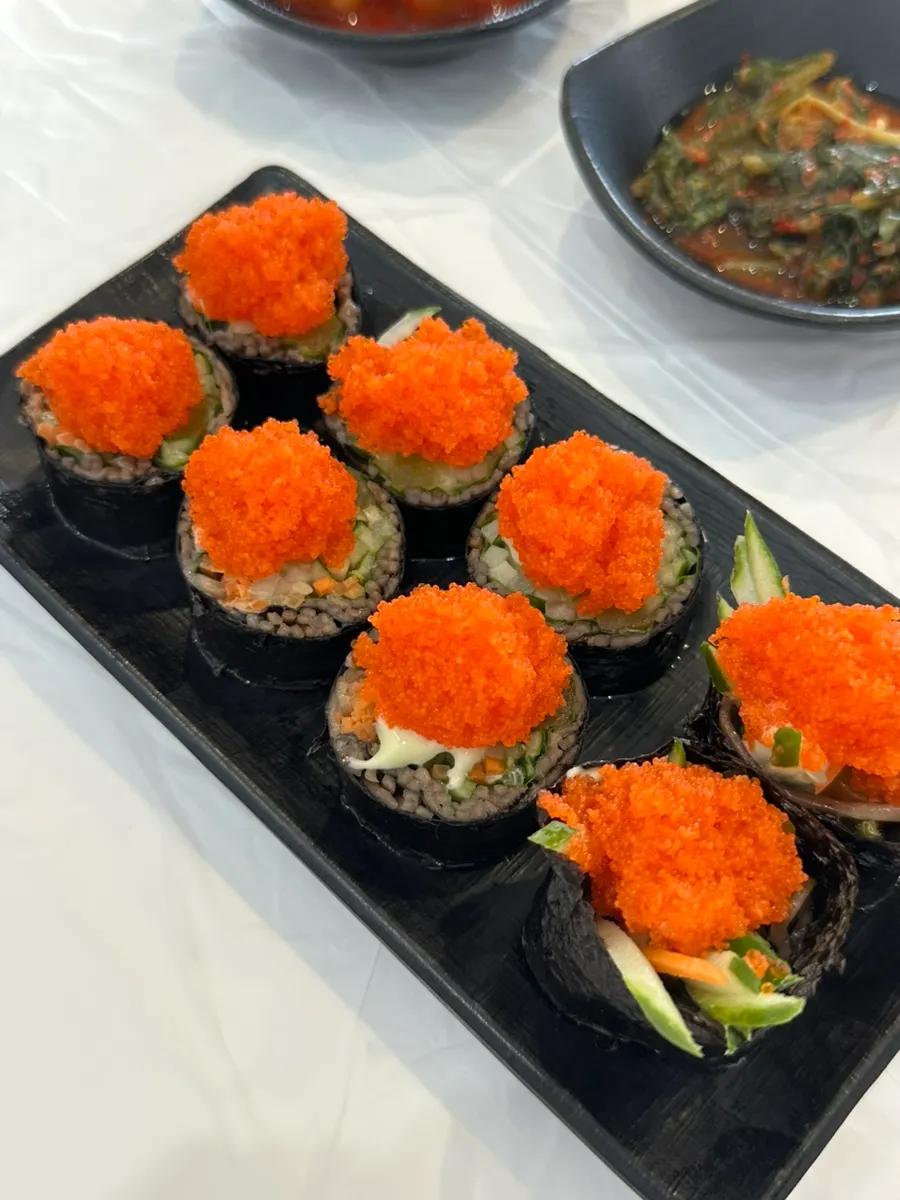 A plate of buckwheat gimbap piled high with flying fish roe