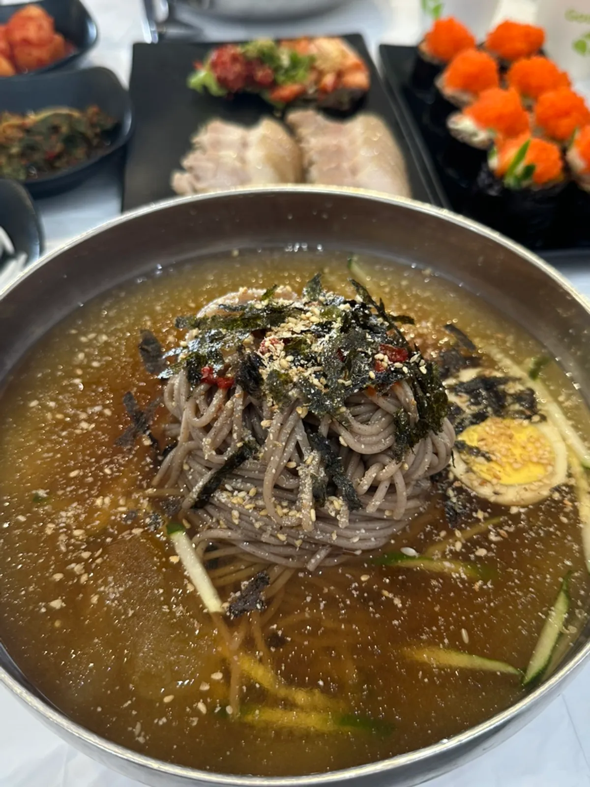 A bowl of water makguksu with floating ice flecks