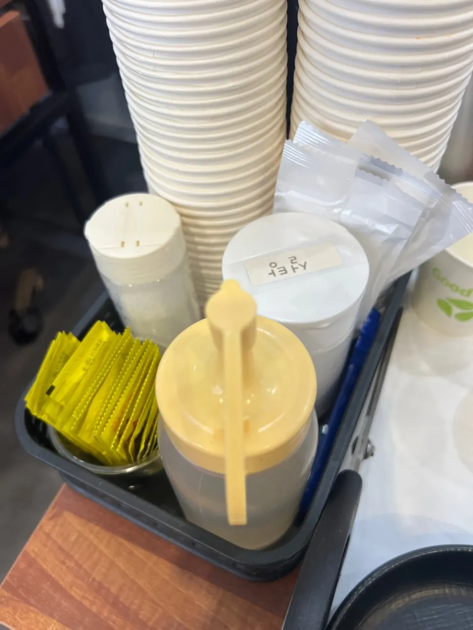 Mustard, sugar, and vinegar condiment containers on the table