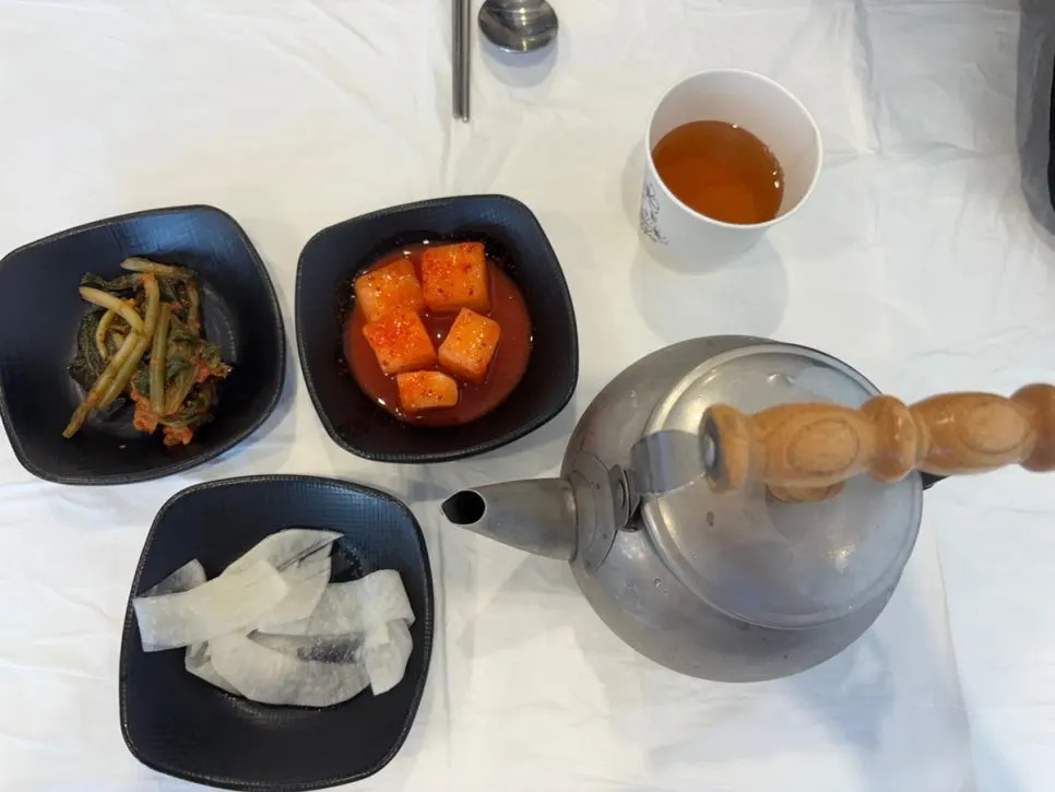 기본 반찬과 냉육수가 놓인 테이블