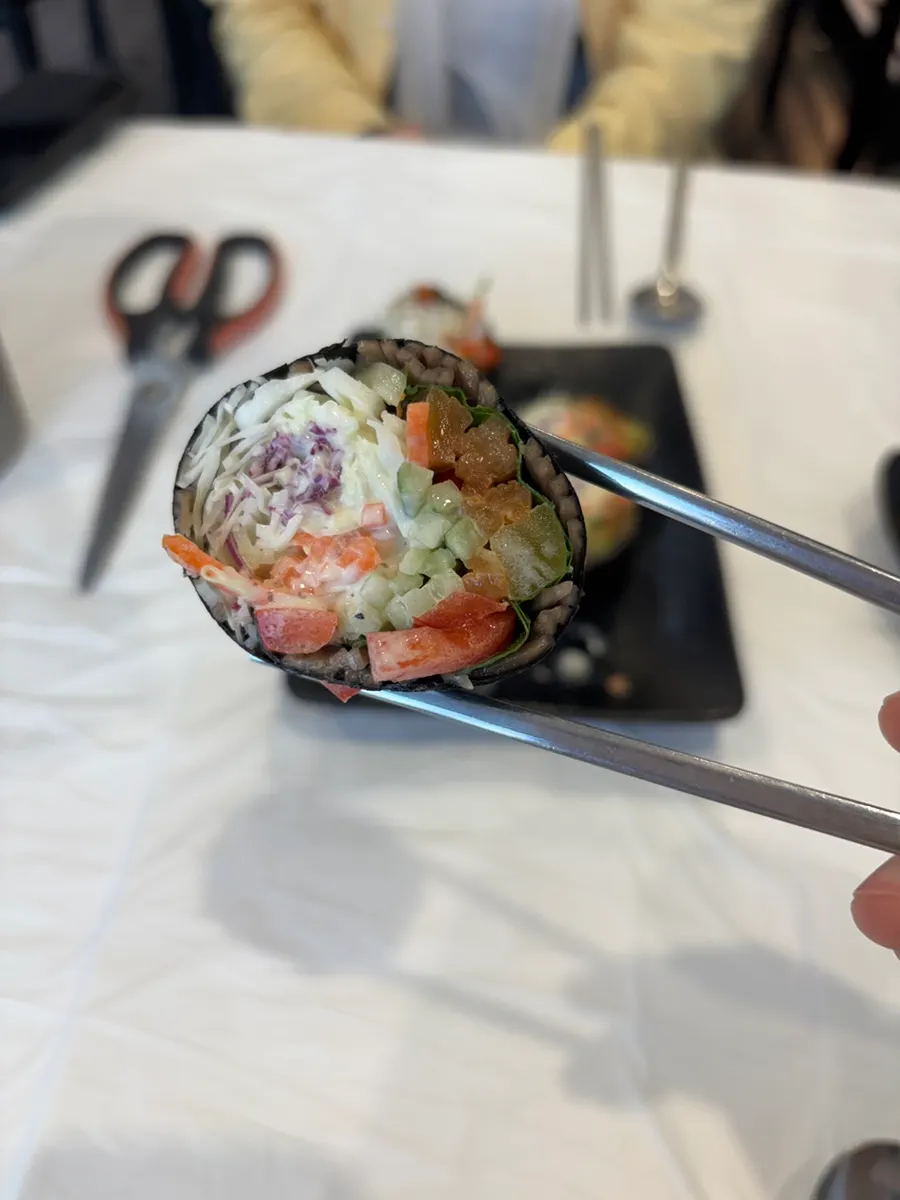 젓가락으로 집어 든 샐러드 메밀김밥