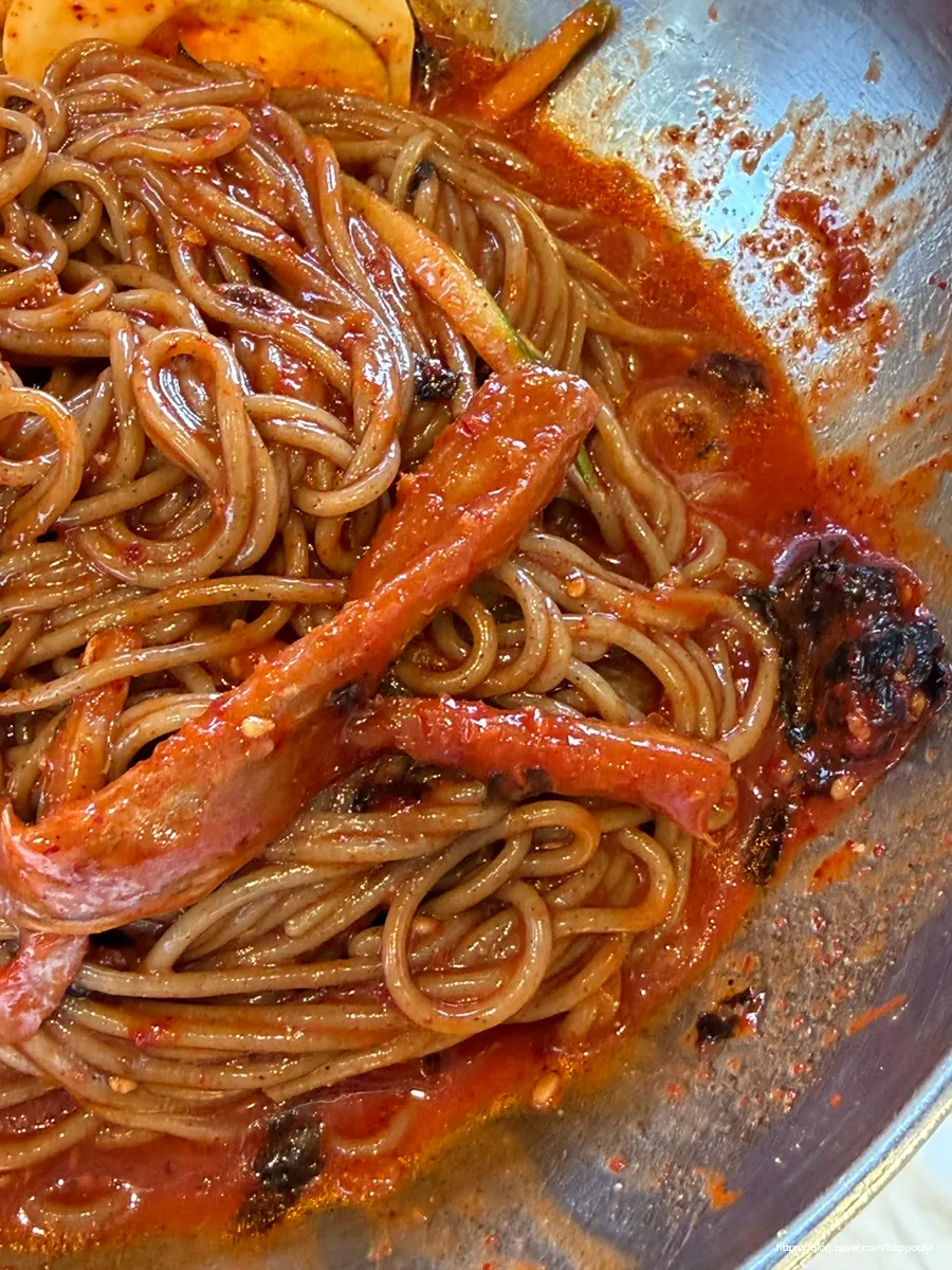 A bite of bibim makguksu topped with pollack sashimi