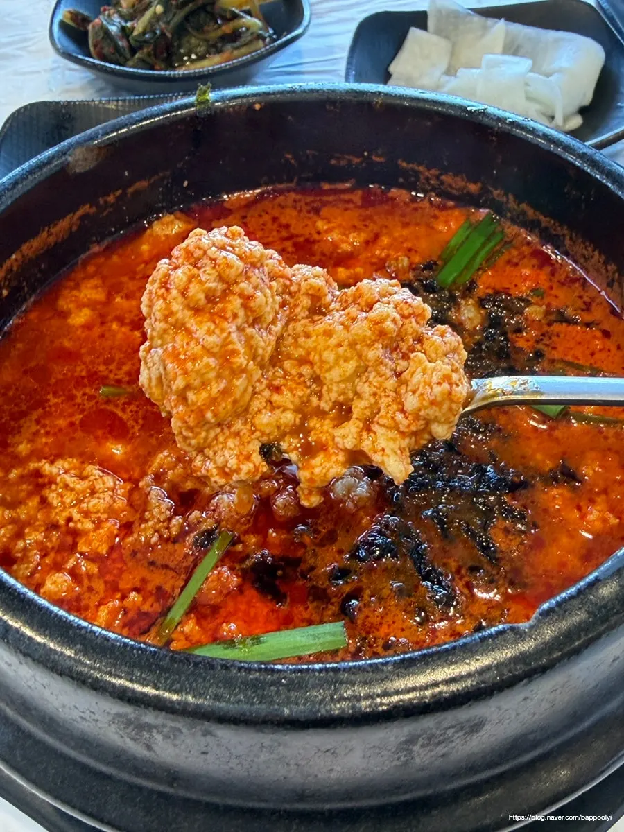 A spoonful of sundubu lifted up